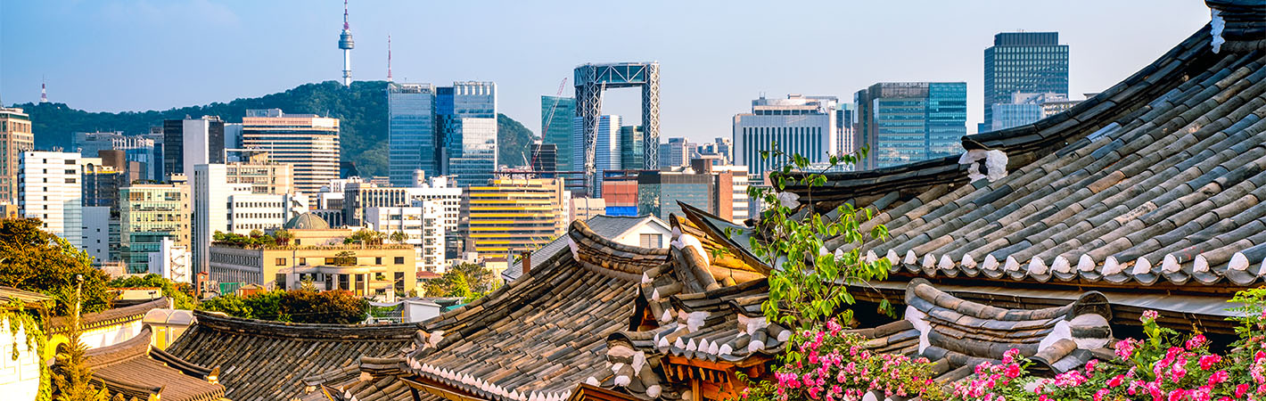 Ansicht von Seoul mit traditionellen koreanischen Häusern im Vordergrund und Wolkenkratzern im Hintergrund